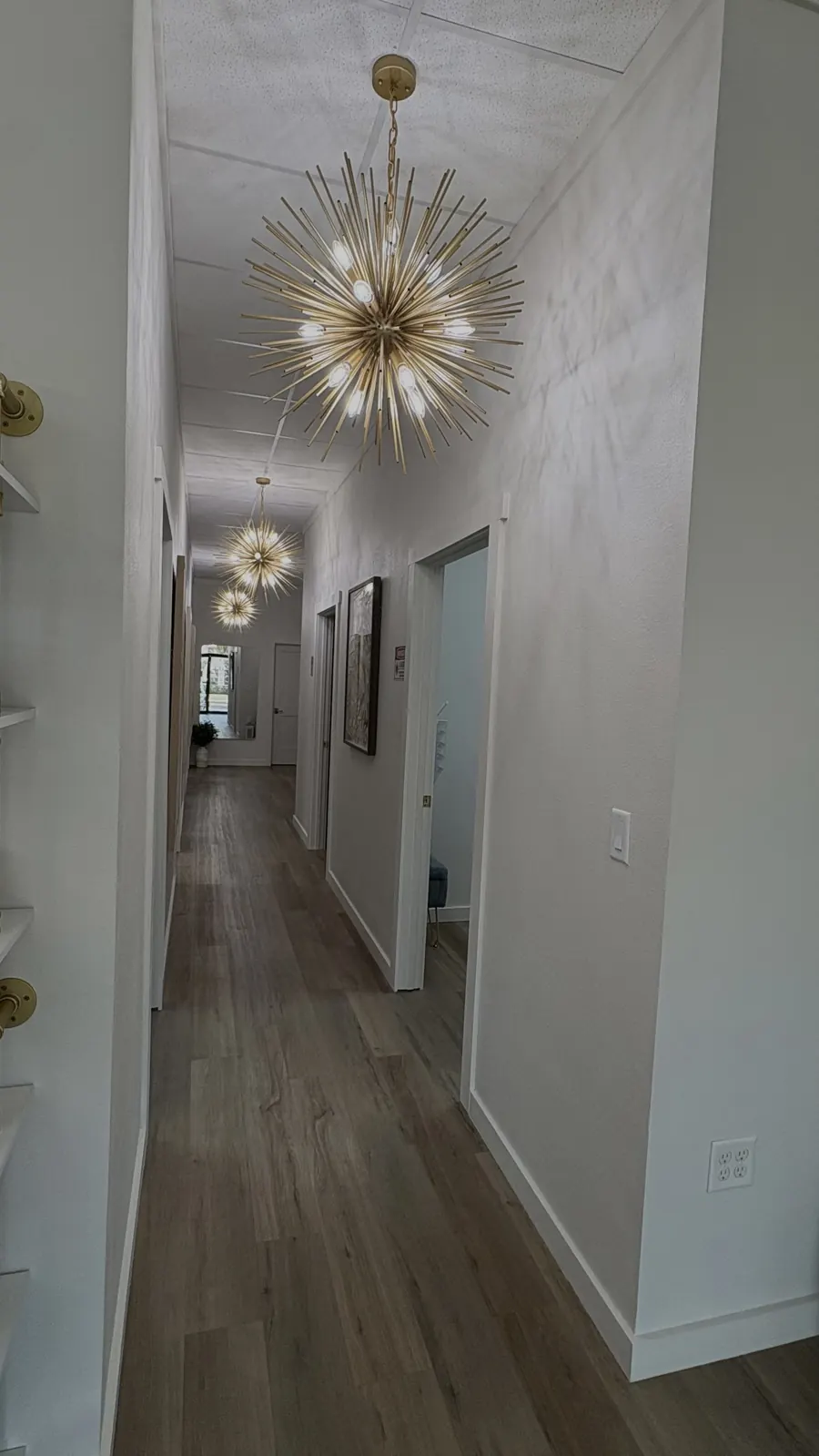 The gold-lit hallway leading to private treatment rooms at GLO in Ocala