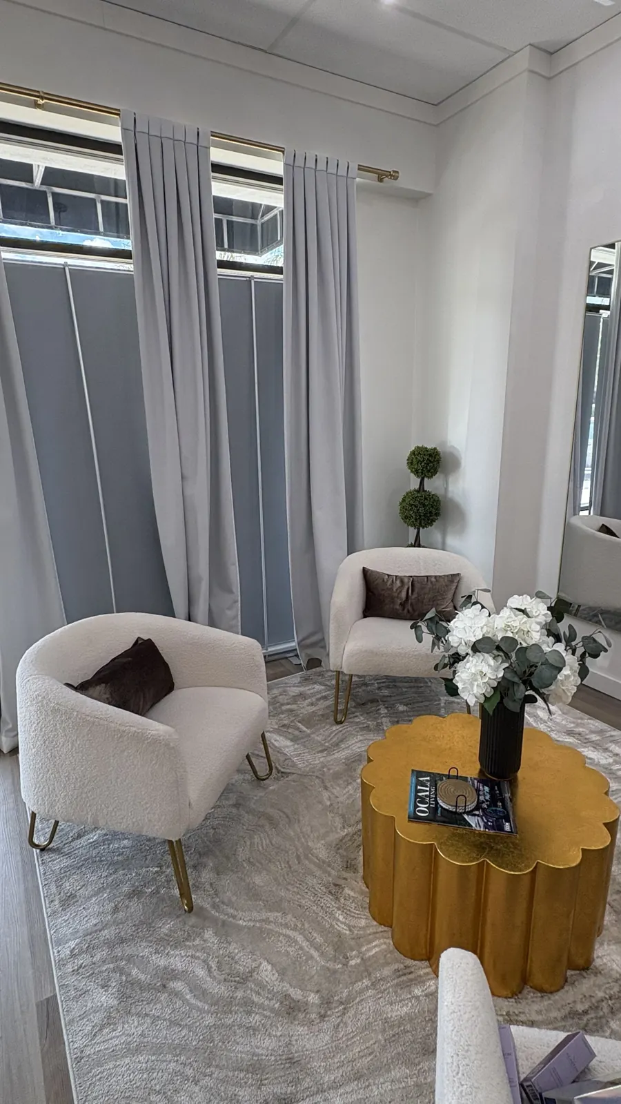 The GLO client lounge in Ocala with soft seating, fresh flowers and gold accents