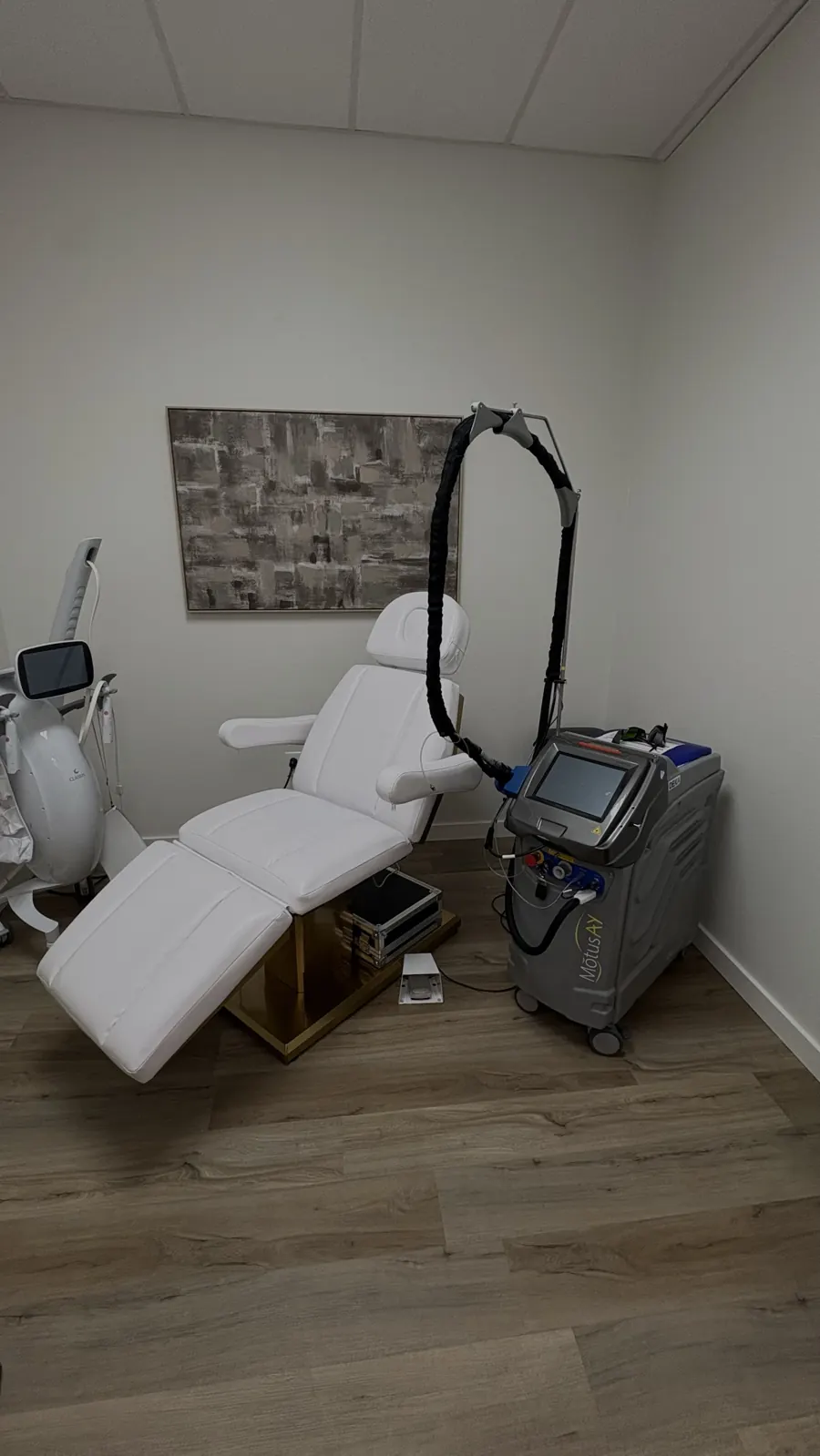 DEKA Motus AY laser beside a white treatment chair at GLO Ocala